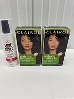 Front view of two Clairol Natural Instincts hair colour boxes and Love Ur Curls treatment bottle