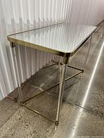 Console table side view showing acrylic legs and gold trim
