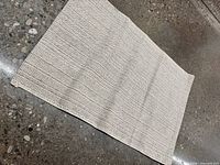 Full view of woven beige rug on floor