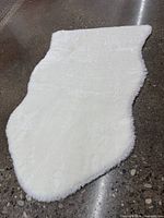 Top view of entire white irregular rug on floor