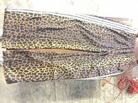 Full length view of leopard print track pants showing pattern and side stripes