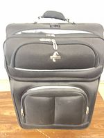 Front view of black Atlantic softside suitcase showing pockets and logo