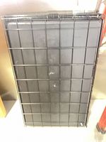 Stacked collapsed black wire dog crate showing exterior and plastic tray