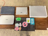 Five closed devices laid out on table showing brands and sizes
