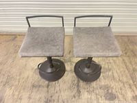 Two bar stools front view showing seats and bases