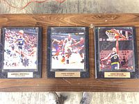 All three signed photo plaques on table