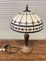 Side view of lamp showing stained glass shade and bronze-tone base