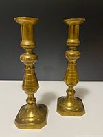 Full view of both brass candlesticks front angle