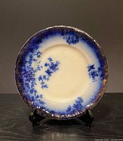 Front view of Flow Blue plate on stand showing full pattern