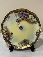 Front view of porcelain plate showing full floral design and gilt rim
