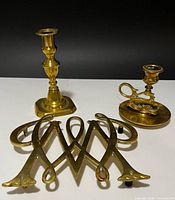 Group shot of brass trivet and two candlesticks