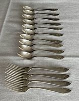 Full set of 10 spoons and 4 forks displayed
