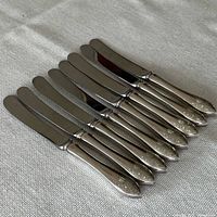 Eight matching Birks Tudor Royal butter knives laid out