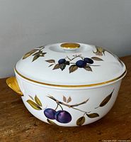 Side view of casserole showing plum motif and gold accents