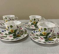 Four demitasse cups with four saucers showing full set