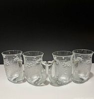 Four frosted glass mugs side by side