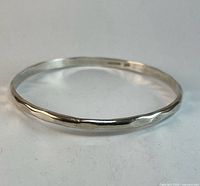 Sterling silver bangle side view showing faceted edge