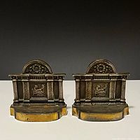Front view of both cast iron bookends showing architectural design and bronze finish