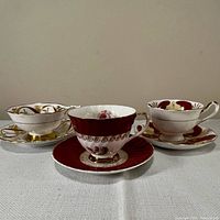 Three teacup and saucer sets grouped together