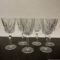 Six cut crystal wine glasses arranged on tabletop