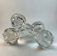 Both knife rests arranged crossing each other showing faceted bodies and cut starburst ends