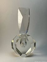 Full front view of faceted crystal perfume bottle with stopper