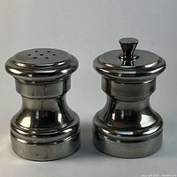 Front view of pewter salt shaker and pepper grinder set