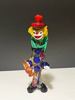 Full view of multicolour Murano glass clown figurine standing on white surface