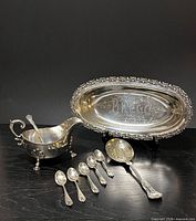 Group shot of platter, gravy boat, five demitasse spoons, berry spoon