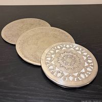three silverplate round trivets grouped