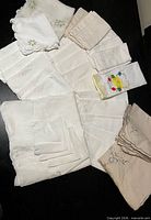 Overview of assorted white and embroidered linens spread out