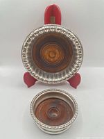 Front view showing both coasters, size difference, wood bases and silver rims