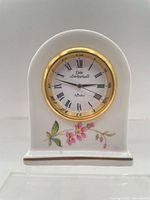 Front view of Aynsley bone china clock showing dial, gold bezel, front floral design