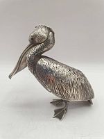 Left-side view of entire pelican figurine showing openwork body and crest