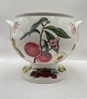 Front view showing fruit motif and pedestal base