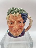 Front view showing Bacchus face, grape cluster, vine handle