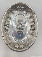 Top view of oval sterling dish showing fruit repoussé and piercings
