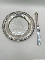 Sterling-rim glass butter dish beside butter knife