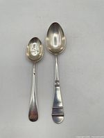 Both sterling silver spoons full length
