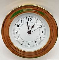 Front view showing brass bezel, white dial, Victory logo, hands and numerals