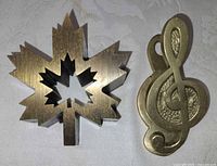 Treble clef clip beside maple leaf paperweight
