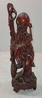 Front view of carved Shou figure showing staff, peach, robes, and base