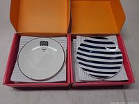 Two boxed sets, showing striped and illustrated plates with cushioning