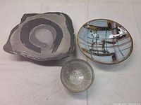 Full view of three items: slate slab, large glazed bowl, small bowl