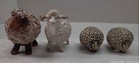 Front view of all four sheep figurines