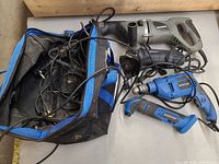 Group shot showing all four corded tools, power cords and tool bag