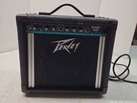 Front view of Peavey Rage 108 combo amp showing control panel, grille, and attached power cord