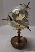 Full view of acrylic globe weather station on brass pedestal