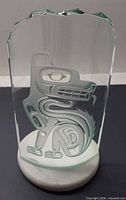 Front view of etched glass wolf sculpture on marble base