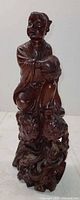 Front view of carved wooden boy figurine on cloud base